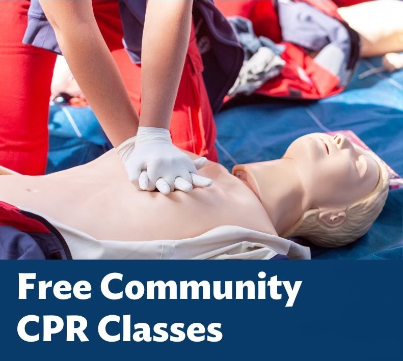 A person performing CPR on a training dummy during a community CPR class, with emphasis on hands-only technique.